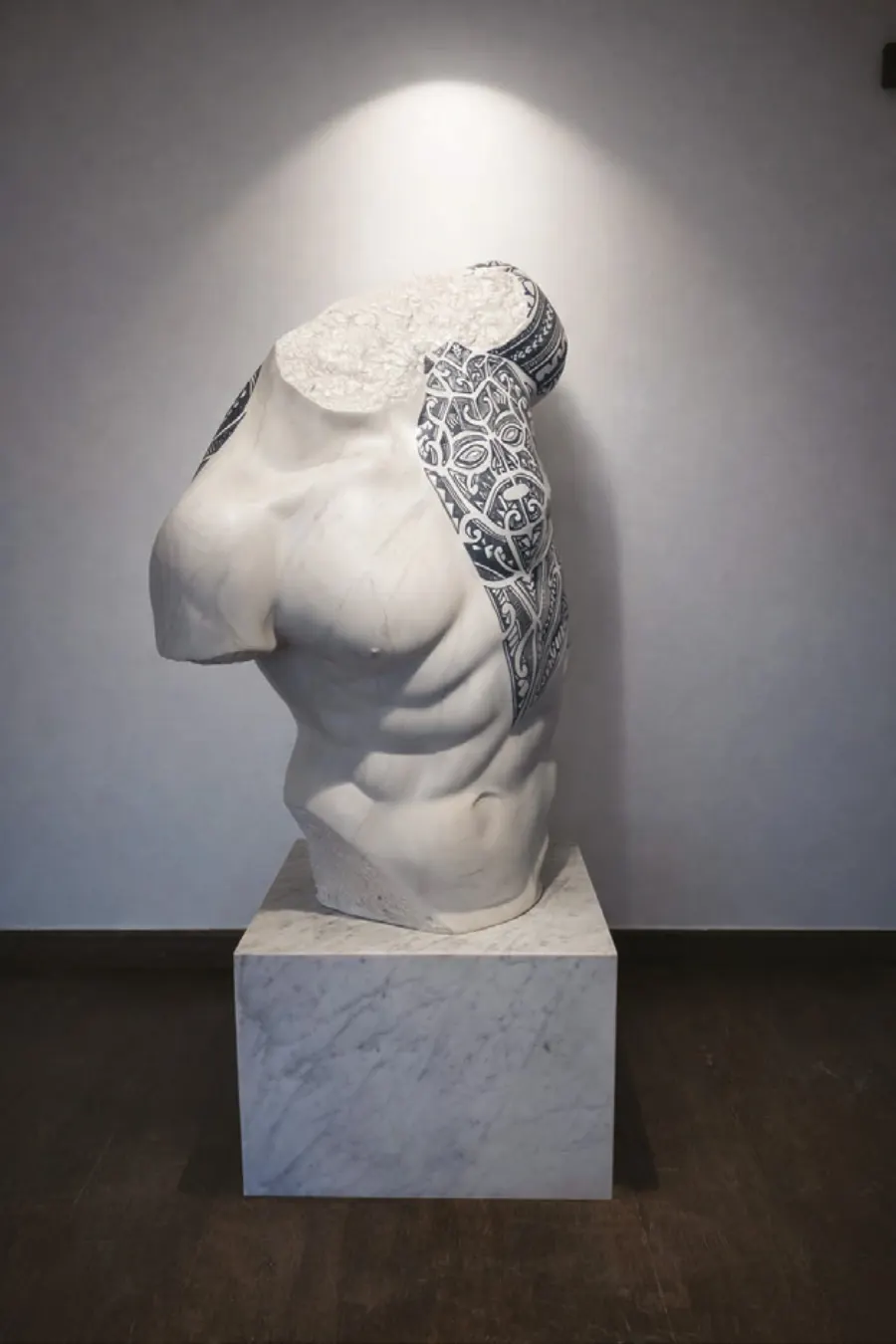Marble-finish sculpted torso on a plinth